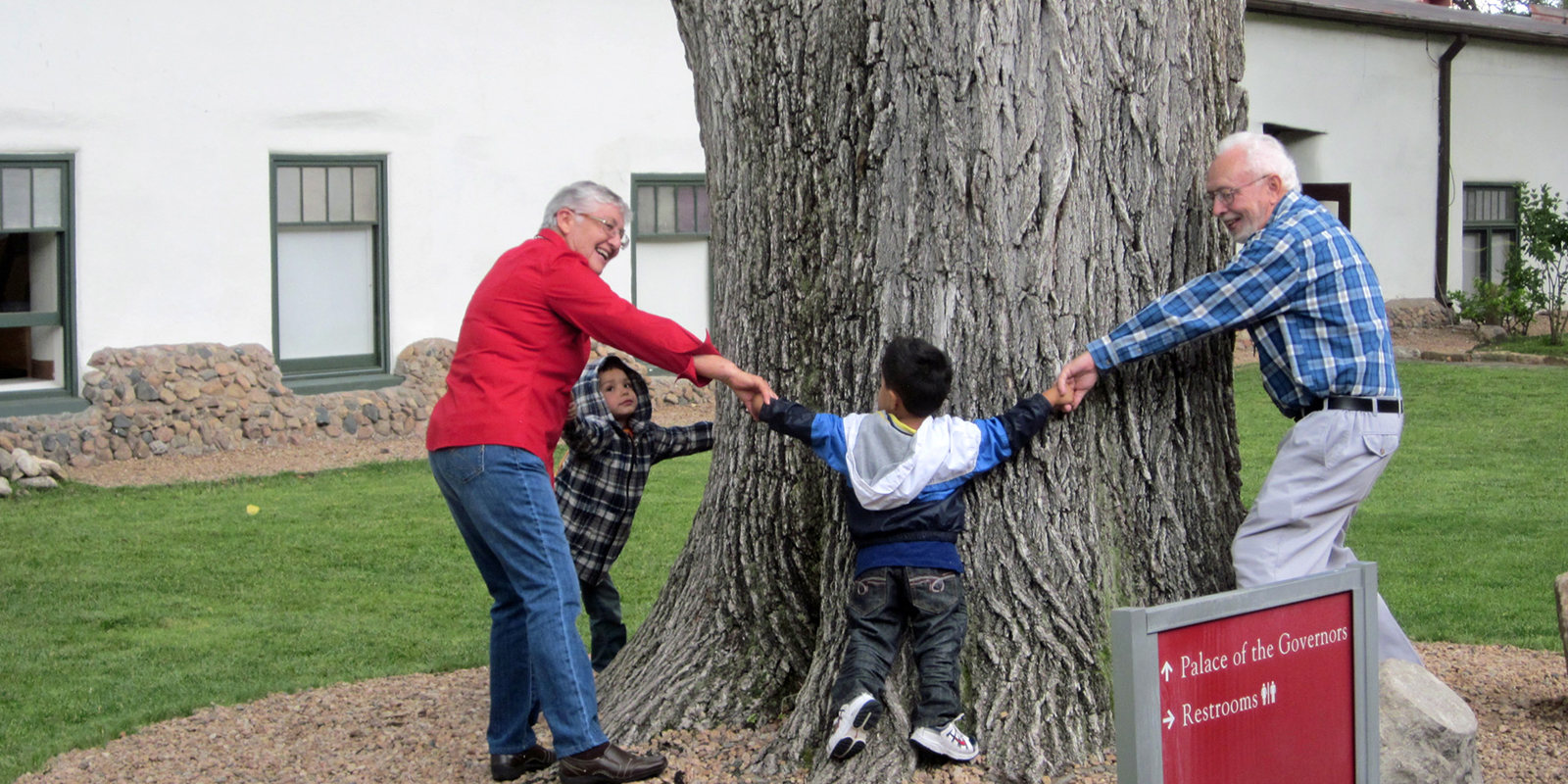 Visitors try to see how many people it takes to circle an elm tree in the courtyard. Photo by Kate Nelson